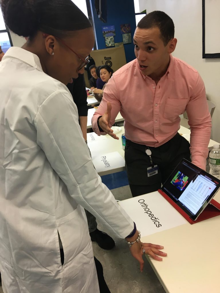 Kayla Simpson learning about orthopedics from TouroCOM DO student at specialties fair. 2019